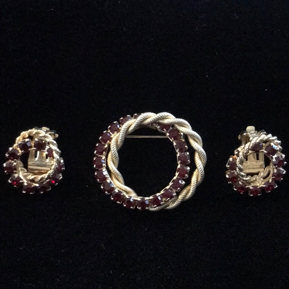 Vintage entwined gold tone brooch and earrings with deep red rhinestones.
